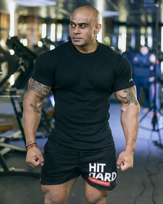 Strong Soul black ribbed slim fit t-shirt and training shorts with HIT HARD graphic on a muscular man in a gym.