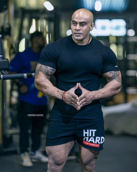 Strong Soul black ribbed slim fit t-shirt and training shorts with HIT HARD graphic. Muscular man posing in gym.